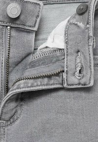 Pantaloni din denim gri, cu fermoar la brâu, având un buton metalic, buzunar interior și margini distruse ale materialului aproape de talie.