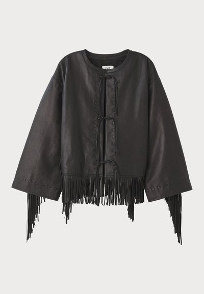 Chaqueta de cuero negro recortada con mangas amplias, con un cierre frontal de cordones y detalles de flecos a lo largo del dobladillo y las mangas.