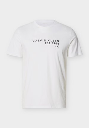 T-shirt bianca a maniche corte con testo nero "CALVIN KLEIN EST. 1968" e piccolo logo "CK" sul petto superiore.