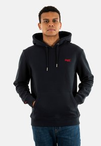 Sudadera azul marino con bolsillo frontal, capucha con cordón y logo rojo bordado. Hecha de una tela suave, con puños y dobladillo acanalados.