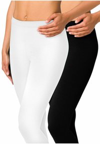 Twee paren leggings: één in effen wit en de andere in effen zwart, gemaakt van een zachte, rekbare stof met een gladde textuur.