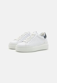 Hvite lær sneakers med teksturert overflate, rund tå, flat hvit såle og grå aksent på hælen. Snøring og perforert detaljer.
