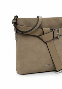 Sac bandoulière en daim et cuir beige avec sangle réglable à boucle et petit logo de marque argenté en bas à droite sur le devant.