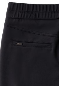 Pantalones de tela elástica negra con una cinturilla elástica. Presenta un pequeño bolsillo con cremallera en la parte posterior, con detalles de costura sutiles.