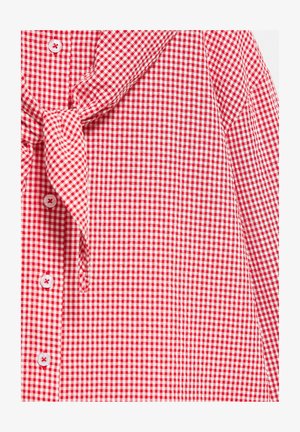Chemise à carreaux vichy rouge et blanche avec boutons sur le devant et un détail en tissu noué au col.