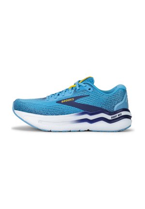 Baskets de course bleu clair avec une tige texturée et des accents marine. Dotées d'une semelle blanche rembourrée et de lacets jaunes. Logo "BROOKS" sur le côté.