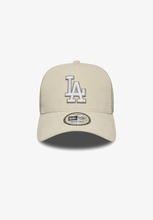 Beige corduroy cap with white embroidered "LA" logo, adjustable back, and rounded peak. Features textured fabric and circular tag on brim.