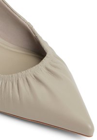 Beige nahkaiset teräväkärkiset ballettiläpäri, jossa on poimutusaukko ja sileä pinta. Pohjassa on hieman kontrastiväriä.