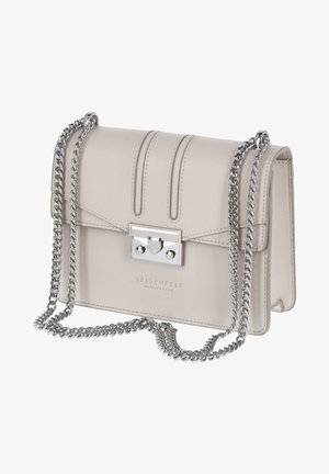 Pieni beige nahkainen olkalaukku, jossa on hopeinen ketjuhihna ja suorakaidehopeinen solki, etuosassa prässätty teksti "Seidenfelt Manufaktur".