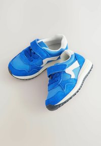 Niebieskie buty sportowe z połączeniem gładkich i teksturowanych materiałów. Wyposażone w rzep, wyściełany kołnierz oraz biały akcent w designie.
