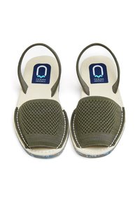 Sandalias de malla verdes con plantilla acolchada. Correa ajustable y detalle de costura blanca. Suela de goma con un diseño en patrón azul.