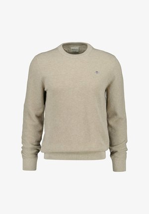 Maglione beige lavorato a maglia con scollo rotondo, polsini e orlo a coste, caratterizzato da un piccolo logo ricamato sul petto. Tessuto testurizzato.