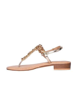 Sandalo basso con cinturini metallici dorati e pietre decorative dorate sulla parte anteriore, con tacco basso in legno impilato e cinturino alla caviglia.