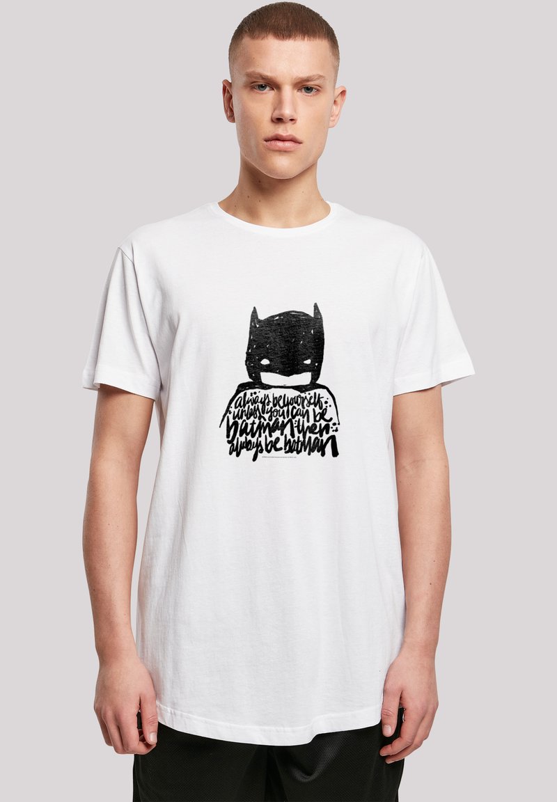 Hvit bomulls T-skjorte med svart grafikk av en maskert figur og tekst, med korte ermer og rund hals.