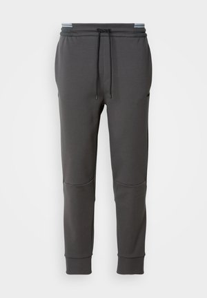 Charcoal grey sweatpants with elastic waistband, adjustable drawstring, side pockets, and ribbed cuffs. Smooth texture and fitted design.