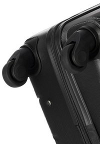 Valise noire à roulettes avec surface texturée, deux roulettes noires durables et une fermeture à glissière, dotée d'un détail de couture renforcée.