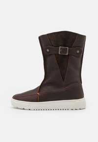 Brown leather boots with a suede upper, featuring a buckle accent, contrasting stitching, a white rubber sole, and a flared silhouette.
