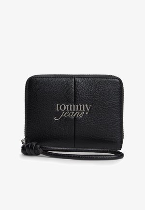 Mustast tekstureeritud nahast käekotike hõbedase "tommy jeans" logoga ja tõmblukuga sulguriga.