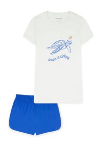 Weißes Baumwoll-T-Shirt mit blauem Schildkröten-Motiv und dem Text „Der Ozean ruft“, kombiniert mit blauen Shorts mit elastischem Bund.