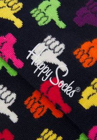 Colorful cotton socks with a black background, featuring varied thumbs-up designs in pink, green, orange, yellow, and white, with "Happy Socks" logo.