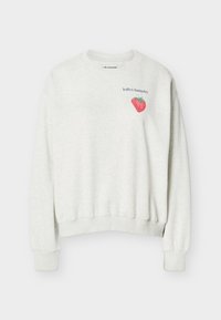 Ανοιχτό γκρι φούτερ με στρογγυλή λαιμόκοψη, με μια μικρή κόκκινη φράουλα και το κείμενο «lollys laundry» στο επάνω αριστερό μέρος του στέρνου.