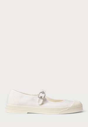 Chaussure plate style Mary Jane en toile blanche avec un embout en caoutchouc et une bride à boucle réglable sur fond clair.