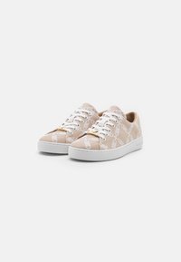 Beige canvas kengät valkoisilla kuvioiduilla yksityiskohdilla, pyöreä kärki, valkoiset nauhat ja kumipohja. Koristeellinen kultainen varuste kielekkeessä.