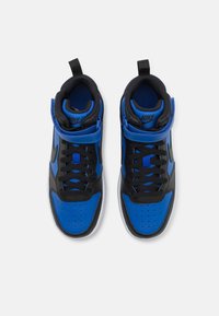 Høyt oppe Nike sneakers med en blå syntetisk overdel, svarte detaljer, svarte lisser og en hvit gummisåle med perforeringer for pusteevne.