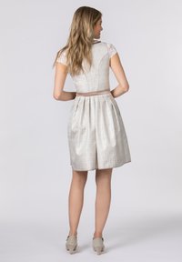 Hellgraues Kleid mit Spitzen-Ärmeln, tailliertem Oberteil und plissiertem Rock. Ein Satin-Taillenband betont die Taille. Canvas-Schuhe vervollständigen den Look.