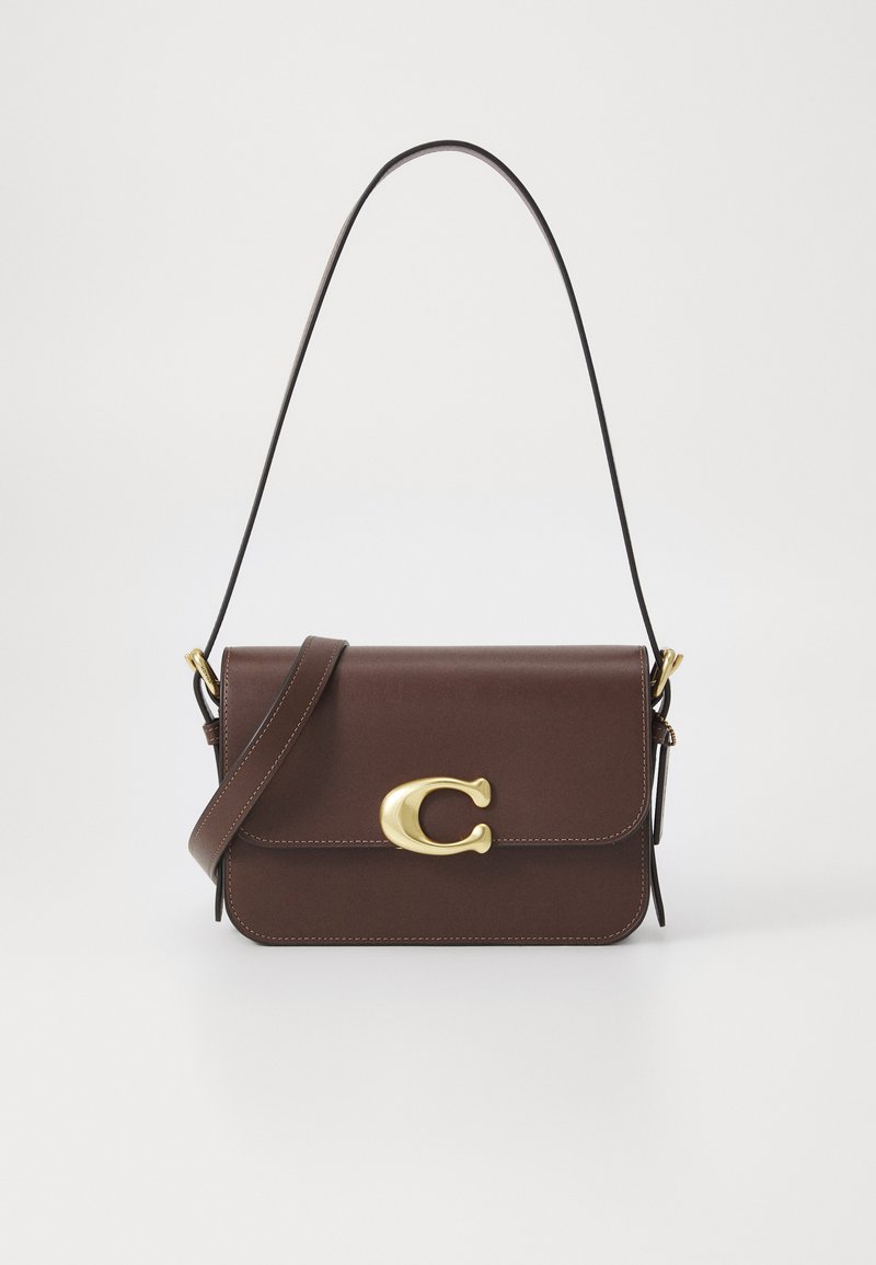 Braune Leder-Handtasche mit einem goldfarbenen Verschluss, der ein "C"-Logo trägt, verstellbarem Schulterriemen und genähten Details entlang der Kanten.