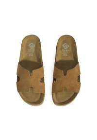 Sandales à enfiler en suède marron avec un design découpé, semelle intérieure texturée et semelle plate, avec le logo de la marque embossé sur la semelle.