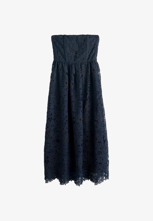 Tumši zila mežģīņu kleita ar bezsiksniņu dizainu un ziedu rakstiem, pieguļoša virsdaļa un plūstoša svārku daļa. Aprīkota ar viļņveida apakšmalu un faktūru audumu.