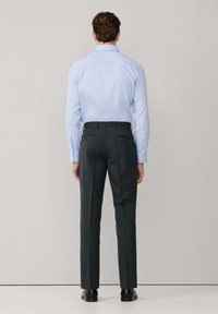 Lichtblauw overhemd met lange mouwen, gecombineerd met donkergrijze op maat gemaakte broek. Glad stof, slim fit en minimalistisch ontwerp.