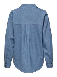 Gaiši zilas krāsas krekls ar garām piedurknēm, attēlots no aizmugures ar plecu yokes šuvi, vidējo locījumu, pogātu aproci un izliekta formas apakšu.