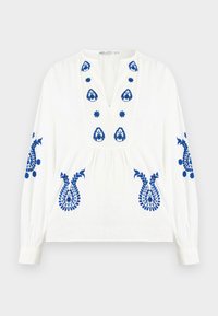 Blouse blanche à manches longues avec broderie florale bleue sur la poitrine, les manches et le bas devant, dotée d'un col en V et d'une taille froncée.