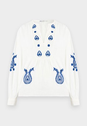 Valge pikkade varrukatega pluus, millel on sinised lillemustriga tikandid rinnal, varrukatel ja alumisel esiosal, V-kaeluse ja kogutud vöökohaga.