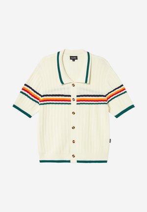 Cardigan tricoté à manches courtes de couleur crème avec col et ourlet verts, boutons marron, et rayures horizontales en vert, violet, orange et jaune sur la poitrine et les manches.