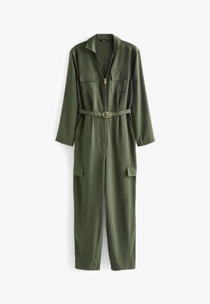 Combinaison à manches longues vert olive avec col, fermeture éclair frontale, ceinture à la taille et quatre poches à rabat : deux sur la poitrine, deux sur les jambes.
