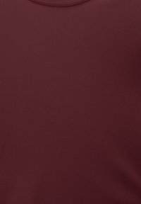Bordeaux T-Shirt aus glattem Baumwollstoff mit rundem Halsausschnitt. Nahtloses Design in einfarbig, ohne sichtbare Texturen oder Muster.