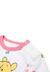 Body blanc pour bébé avec des bordures roses, présentant un motif Winnie l'Ourson et de petits accents décoratifs comme des cœurs et une mouche. Boutons-pression aux épaules.
