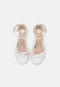Sandales pour femmes en cuir blanc avec brides à la cheville et boucle dorée, comprenant trois brides avant et des semelles intérieures beiges avec impression dorée.