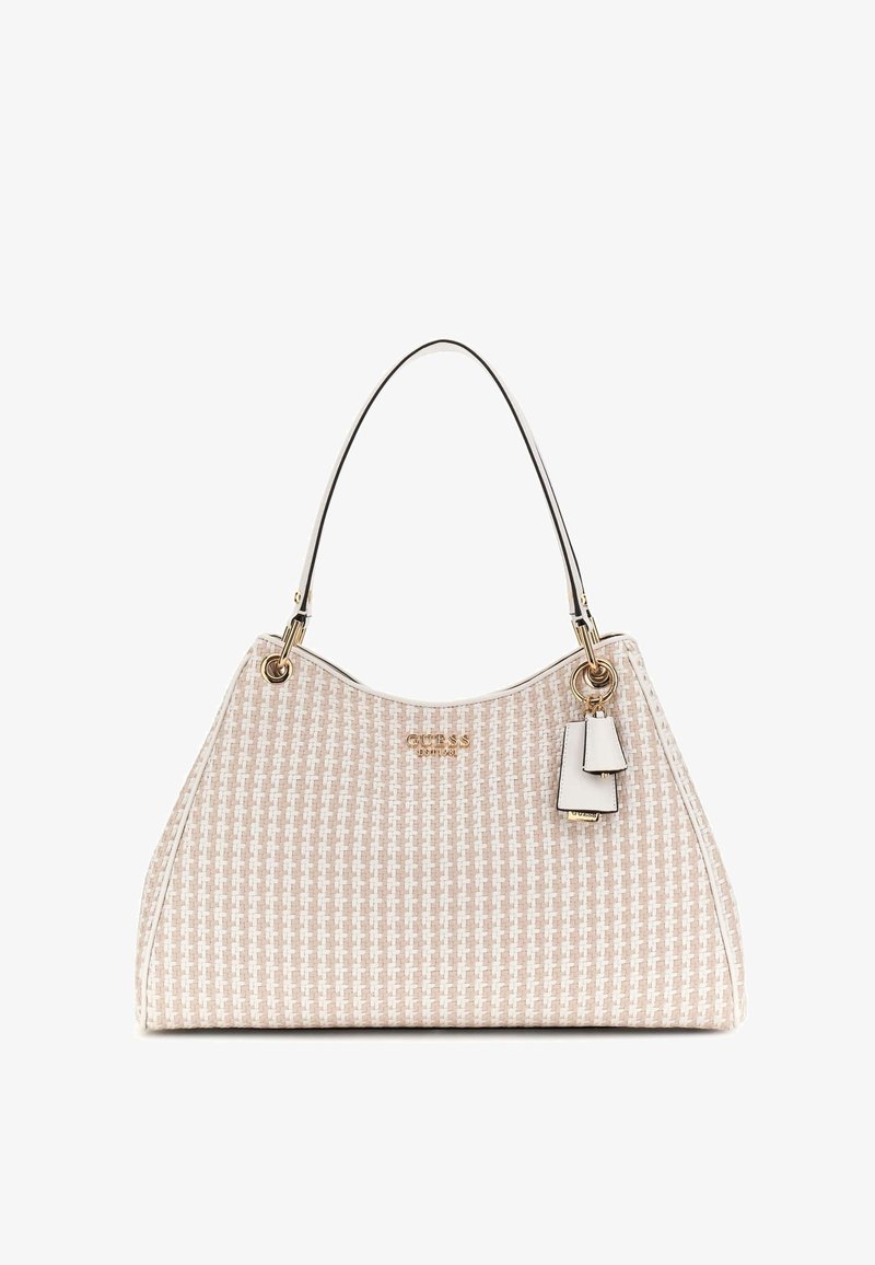 Sac à main beige et blanc à motifs avec une seule bandoulière fine, logo de marque doré et deux petites étiquettes blanches suspendues sur le côté droit.