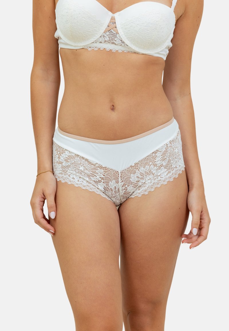 Ensemble de lingerie en dentelle blanche et microfibre comprenant un bralette avec de la dentelle décorative et des culottes taille haute assorties ornées de dentelle florale.