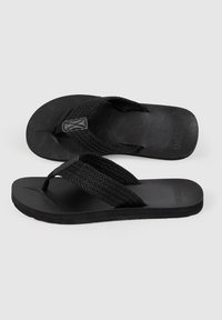Svarta flip-flops med mönstrad gummisula, med flätade remmar och en matt yta. Designade för avslappnad användning och lätt komfort.