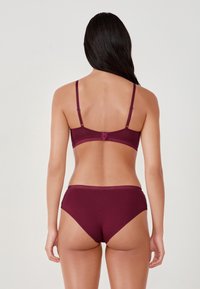 Bordowy zestaw biustonosza i majtek wykonany z gładkiego materiału, z regulowanymi ramiączkami i prostym wzorem z koronkowymi wykończeniami.