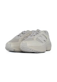Sneakers in una tonalità grigio chiaro, con una tomaia in mesh testurizzato, suola imbottita e dettagli tonali. Forma arrotondata con una suola in gomma prominente.