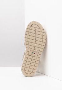 Soletta di scarpa beige chiaro con motivo testurizzato per la presa, contrassegnata con "NeroGiardini," taglia 37, e incisione "Made in Italy."