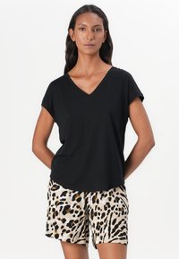 Black V-neck t-shirt with short sleeves, paired with beige shorts featuring a black and gold leopard print pattern. Smooth fabric texture.