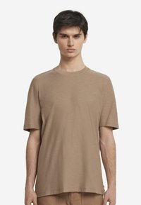 Brun kortærmet T-shirt med rund halsudskæring og en afslappet pasform lavet af blødt, tekstureret stof. Enkel design uden mønstre.