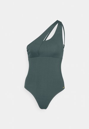 Maillot de bain asymétrique vert foncé avec une texture lisse, présentant un détail découpé et une sangle ajustable, conçu pour une silhouette ajustée.